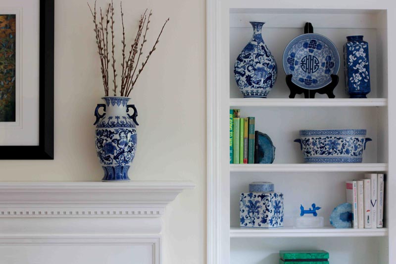 painted white wood trim mantel with blue and white vase and painted wood trim built-in-bookcase 