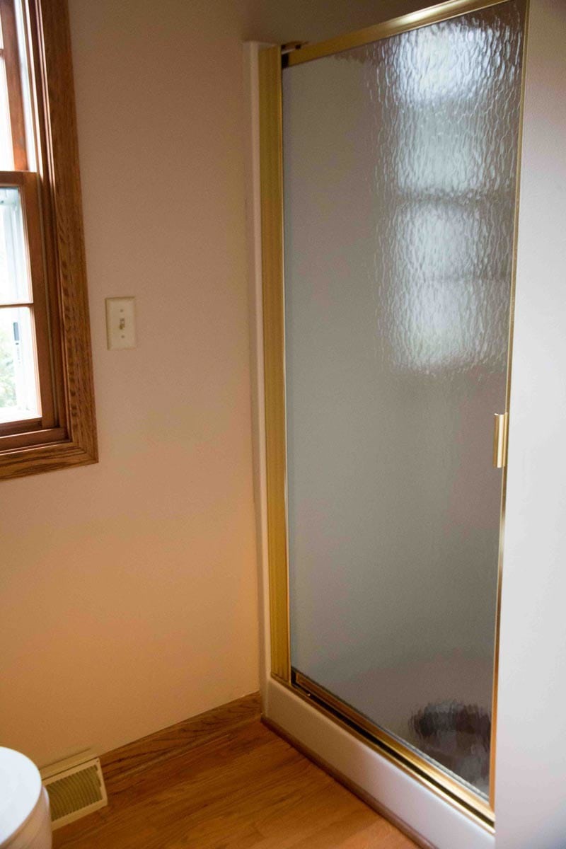 brown bathroom gold shower door wood trim