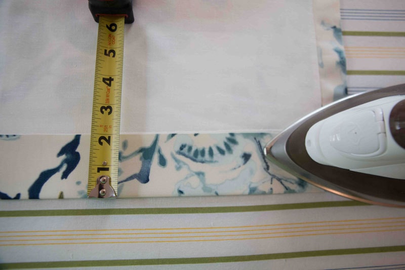 iron and measuring tape on ironing board smoothing DIY roman shades