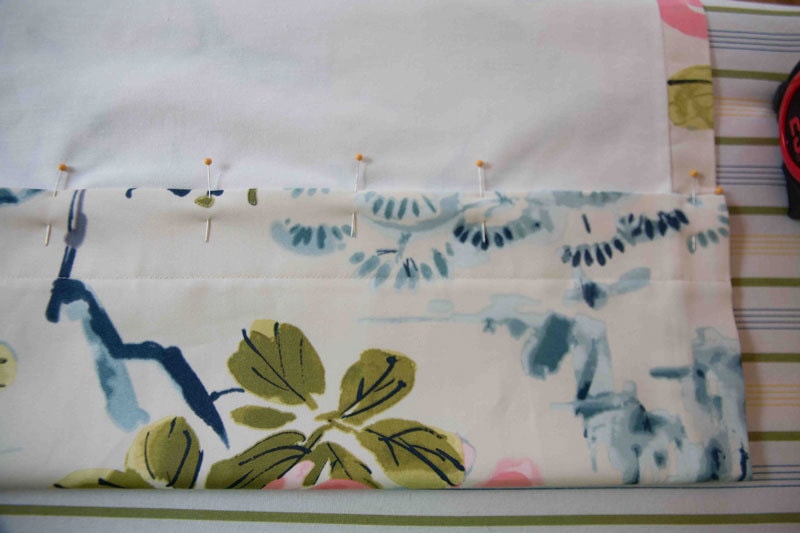 pins holding fabric and liner together in DIY Roman Curtains tutorial