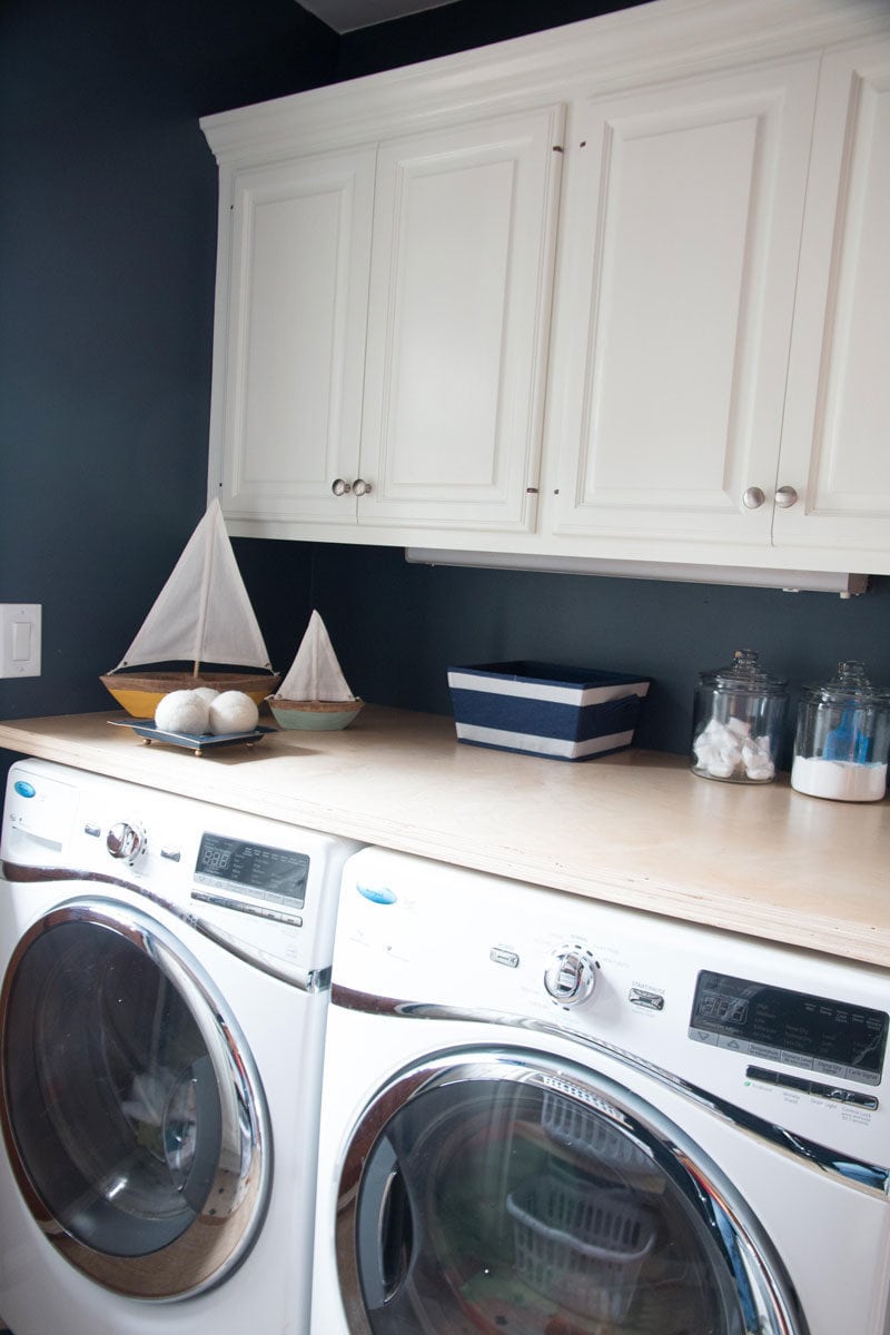 how to paint cabinets--navy blue laundry room and white laundry room cabinets with plywood countertop