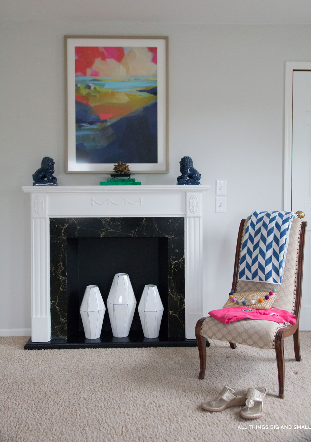 blue and white accents in a gray master bedroom with white fireplace