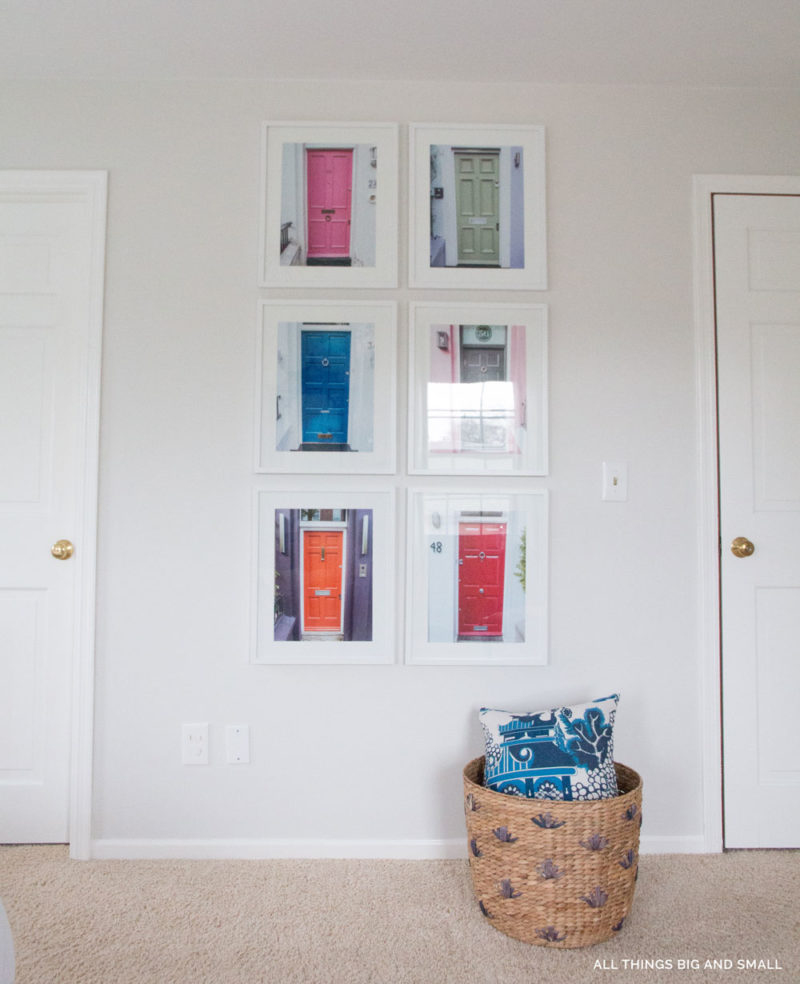 Benjamin Moore Classic Gray on bedroom walls with white frames in grid and basket on floor. Simply White on trim and door