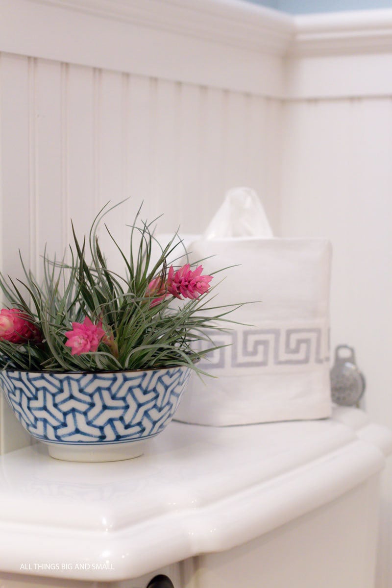 up close shot of beadboard bathroom walls with toilet and pedestal sink