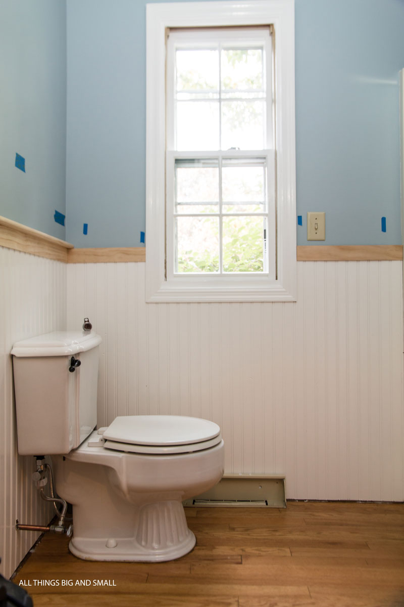 beadboard bathroom installation progress with blue walls and white beadboard