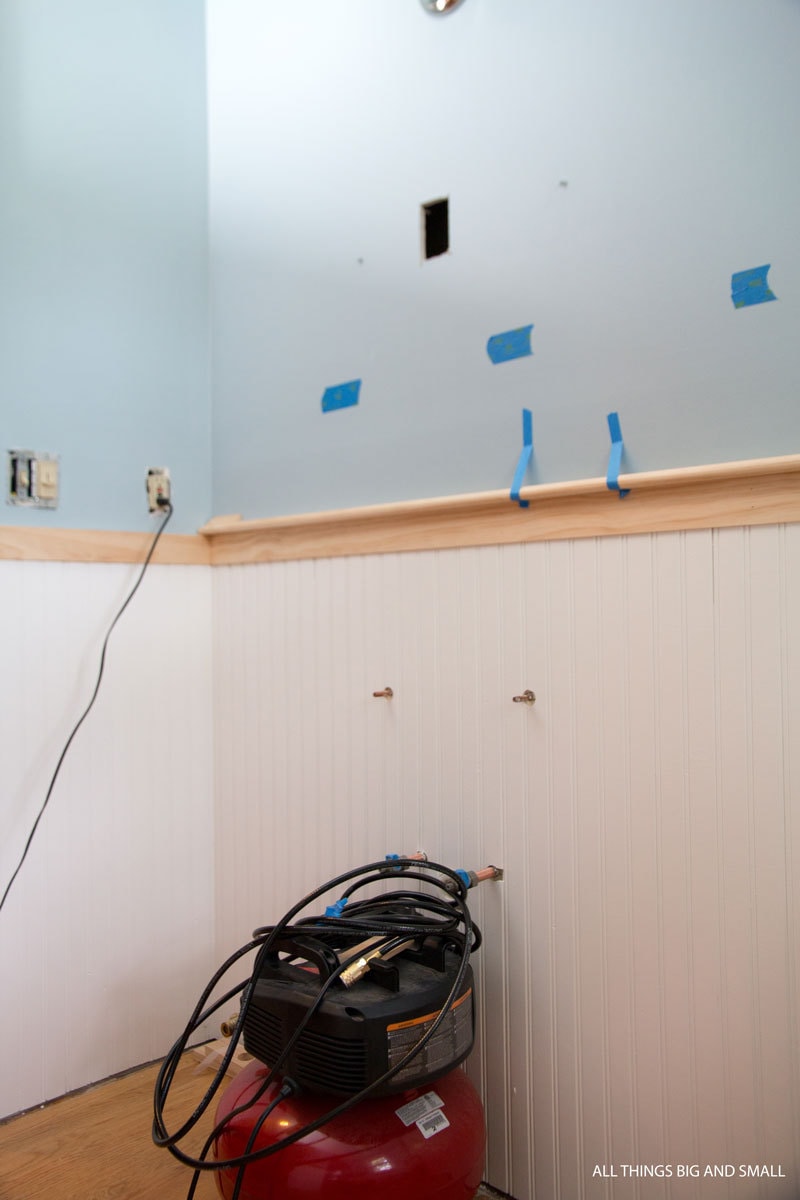 use painter's tape to hold trim pieces in beadboard bathroom to mock up prototypes