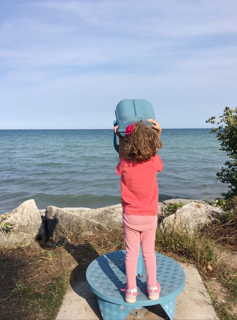 girl looking out of telescope--summer activities and schedule for kids that keep them busy