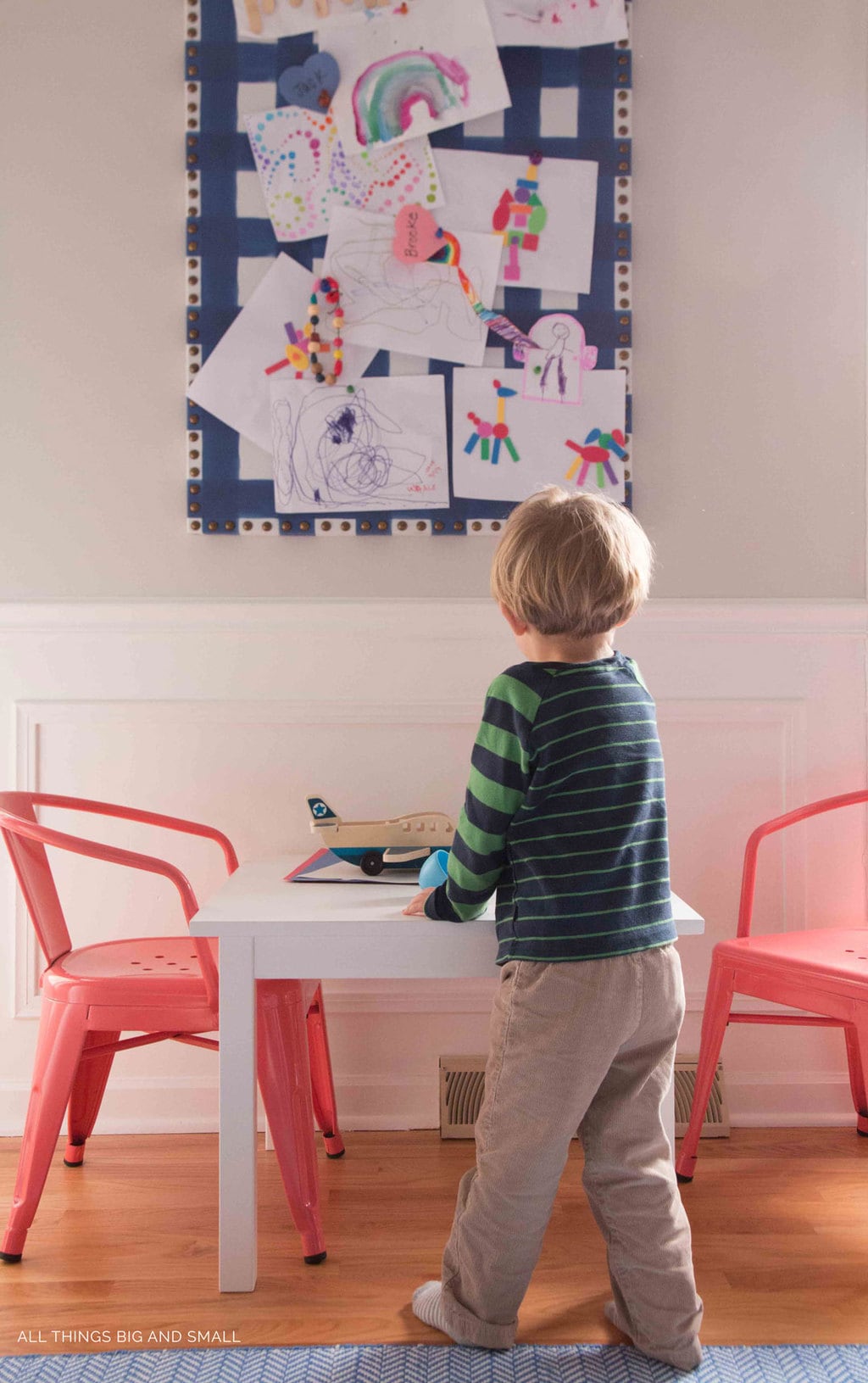 boy playing with wooden airplane in colorful playroom decor makeover 