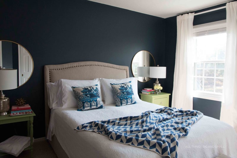 navy walls and blue and white bedroom with blue and white bedding and white curtains