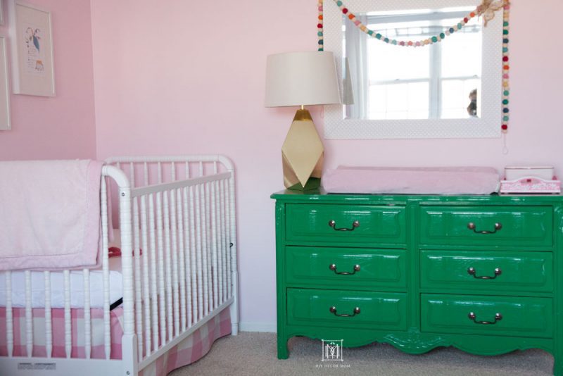 love this shared girls bedroom with a white crib and a green dresser in a pink nursery