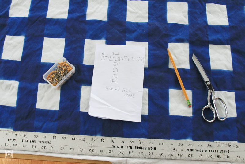 blue buffalo check fabric and ruler and pins for DIY fabric covered bulletin board