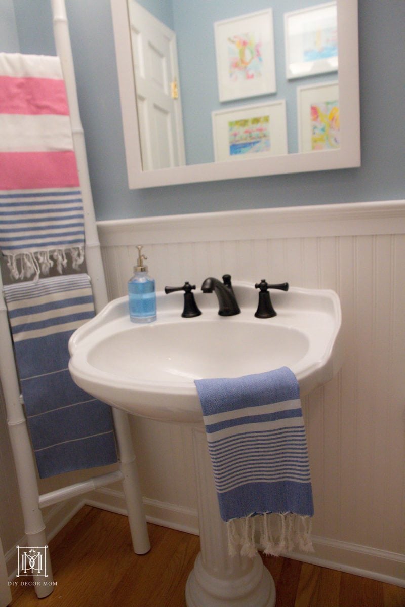 blue and white bathroom with pink turkish towels on bamboo ladder on white sink