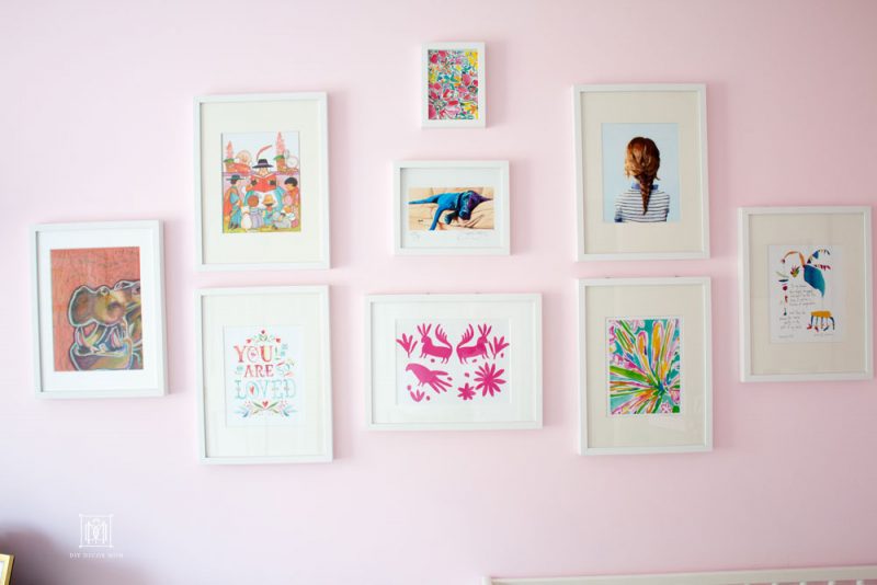 light pink wall color gallery wall in white frames in shared girls bedroom