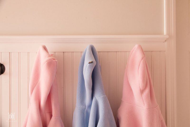 beadboard walls coat hooks and coats hanging in small entryway mudroom