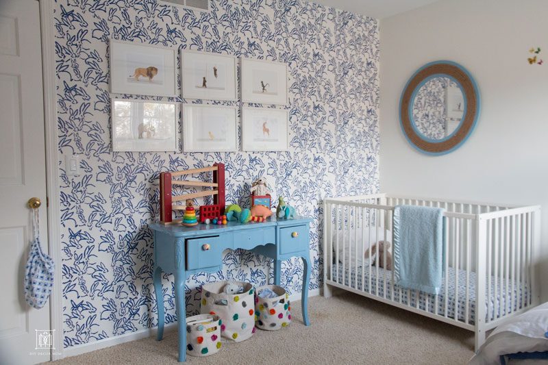 baby boy bedroom- blue and white wallpaper with white crib and blue mirror blue changing table