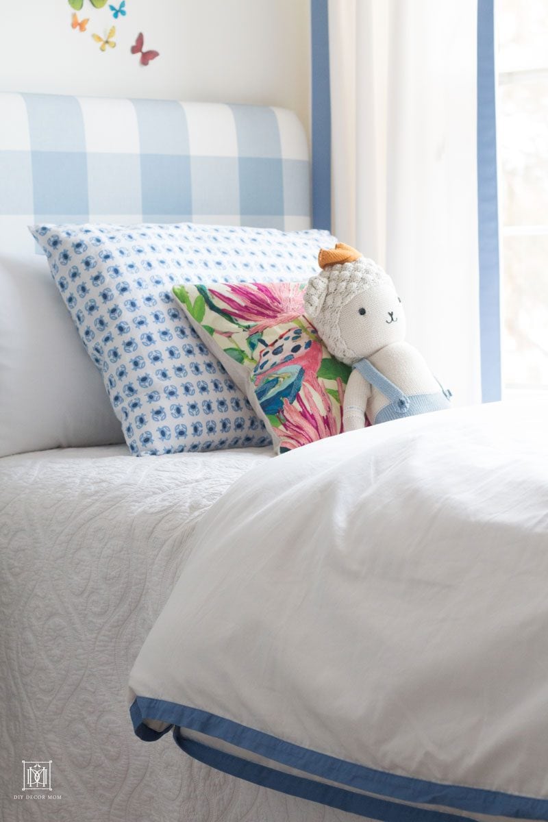 detail shot of blue and white buffalo check bed in front of DIY Curtains and cornice box