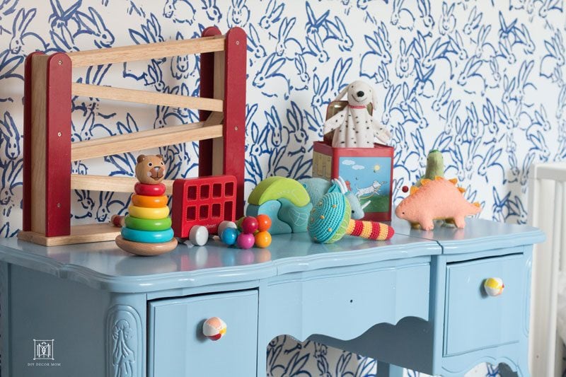 blue and white wallpaper and blue changing table in baby boy nursery