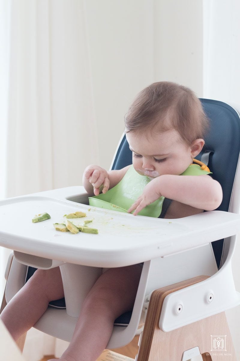 baby eating avocados in a easy to clean high chair