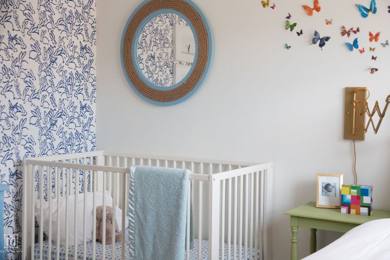 Blue and white wallpaper accent wall Ikea crib and butterfly wall decor in