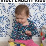 baby reading book while sitting on floor- new mom tips