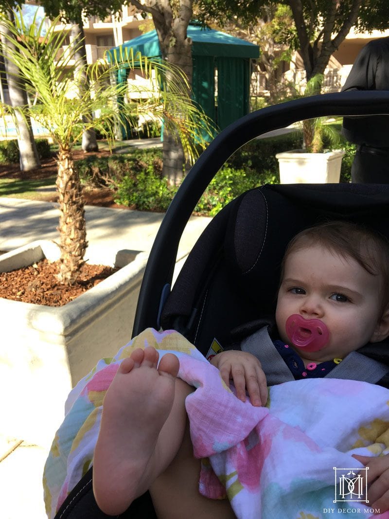 things you need traveling with baby-- picture of baby in stroller next to pool