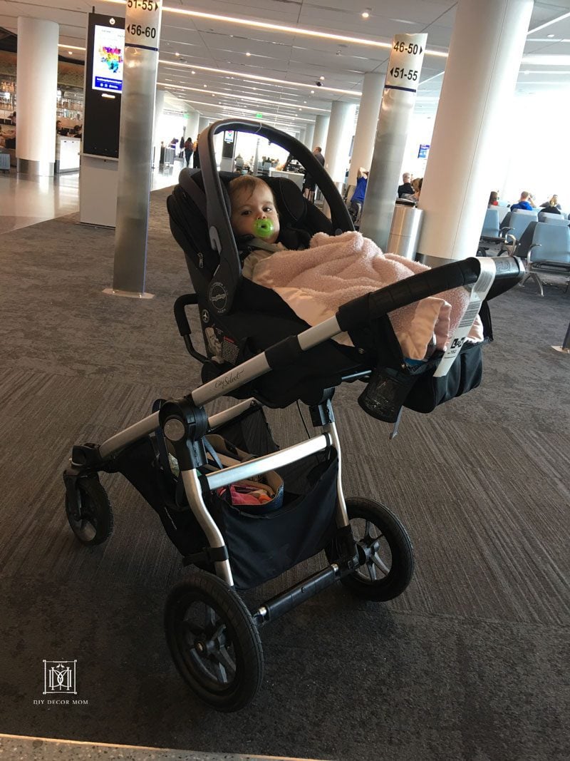 tips for flying with baby- baby in stroller at airport terminal