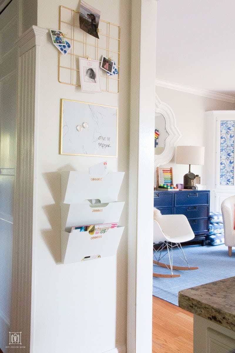 wall mounted family command center on white wall with playroom in the background