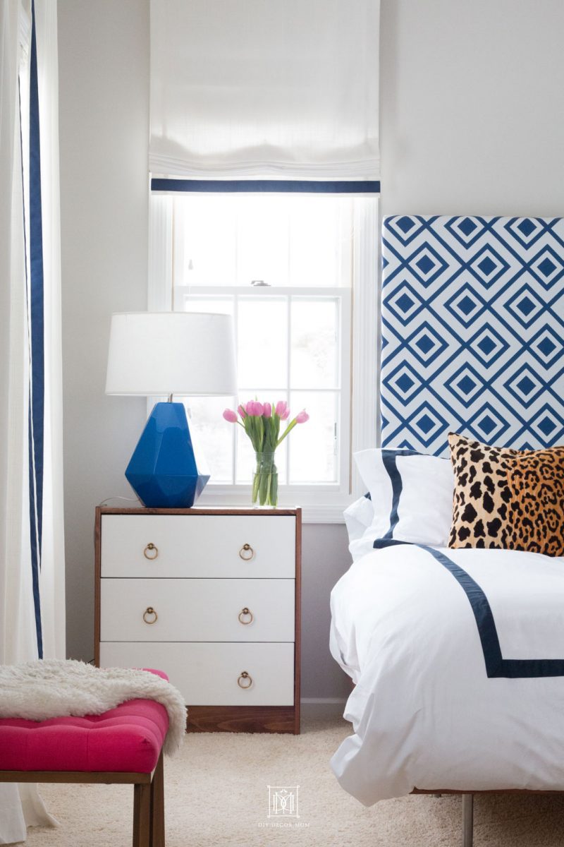 picture of blue and white bedroom with gray walls blue lamp, blue and white curtains and blue and white DIY headboard and leopard throw pillows