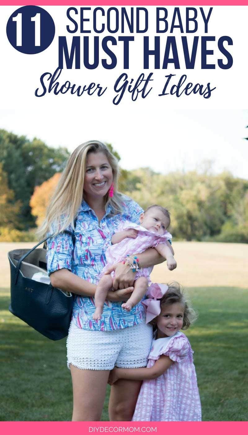 second time mom holds baby and toddler daughter showing baby essentials every mom needs