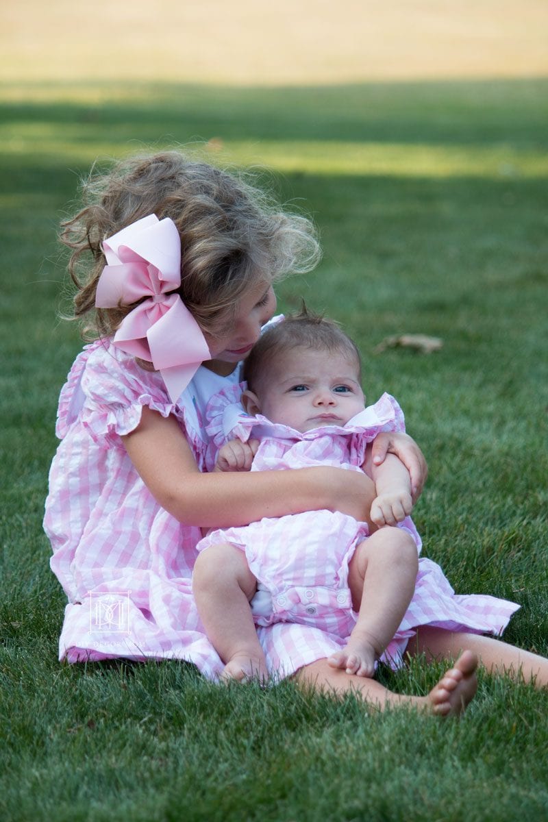 big sister holds newborn baby sister