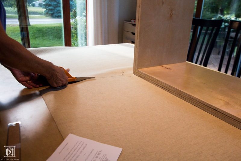 cutting vinyl fabric for diy console table with scissors