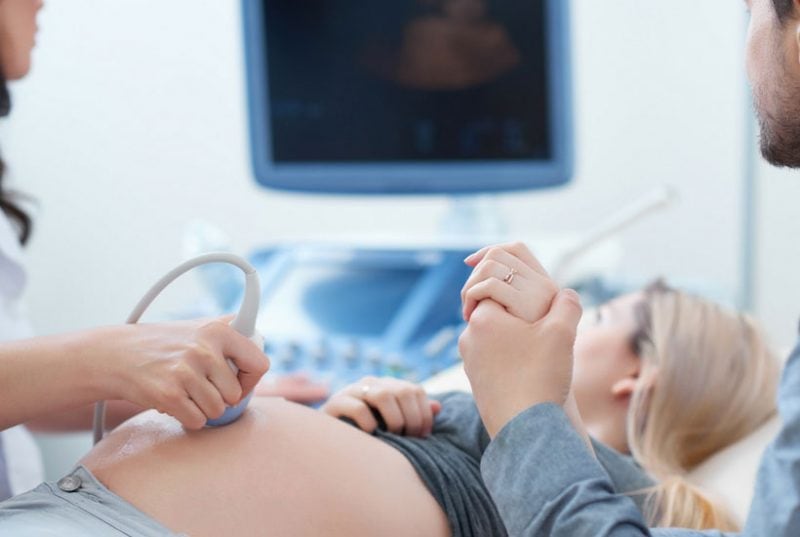 pregnant woman getting ultrasound with husband- things to do second trimester