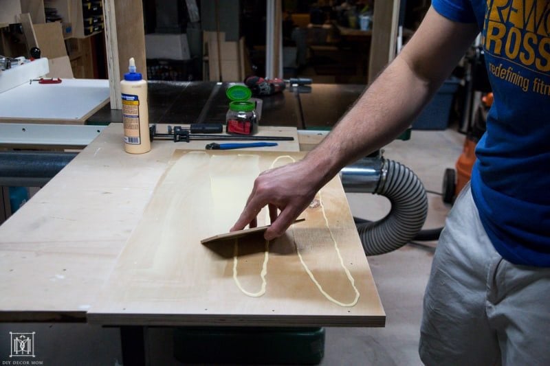 use a piece of wood to spread wood glue to make a diy console table