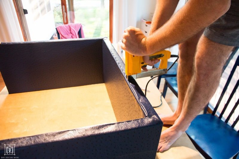 using a staple gun to wrap fabric around diy console table