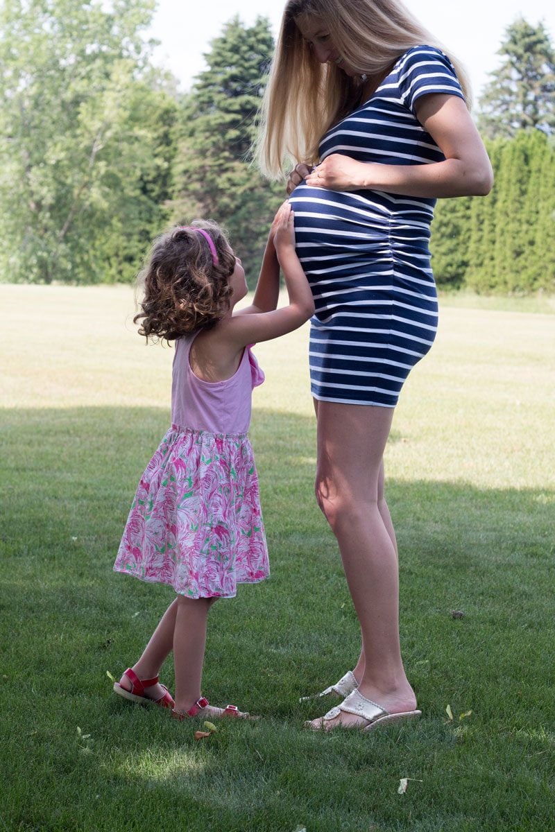 tips to help older siblings adjust to new baby sibling--pregnant mom and toddler daughter hug