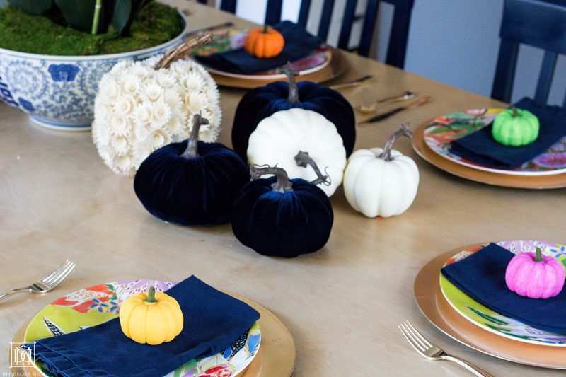 colorful pumpkins on a tablescape with blue napkins and gold chargers