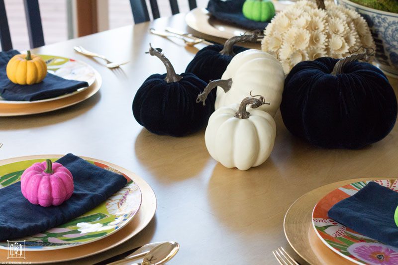 multicolored colorful pumpkin tablescape with navy velvet pumpkins and small colorful pink, yellow, green colored pumpkins