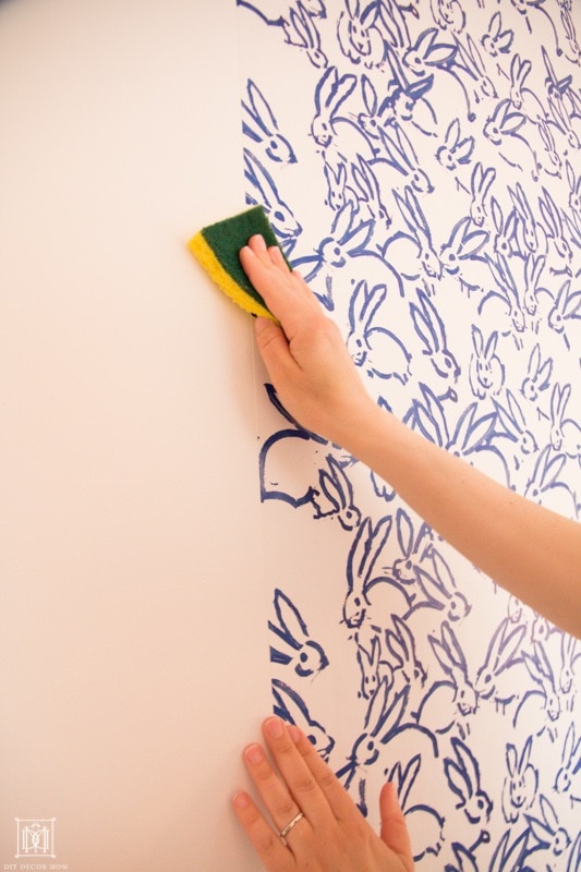 how to hang wallpaper: wipe down the edges with a damp sponge