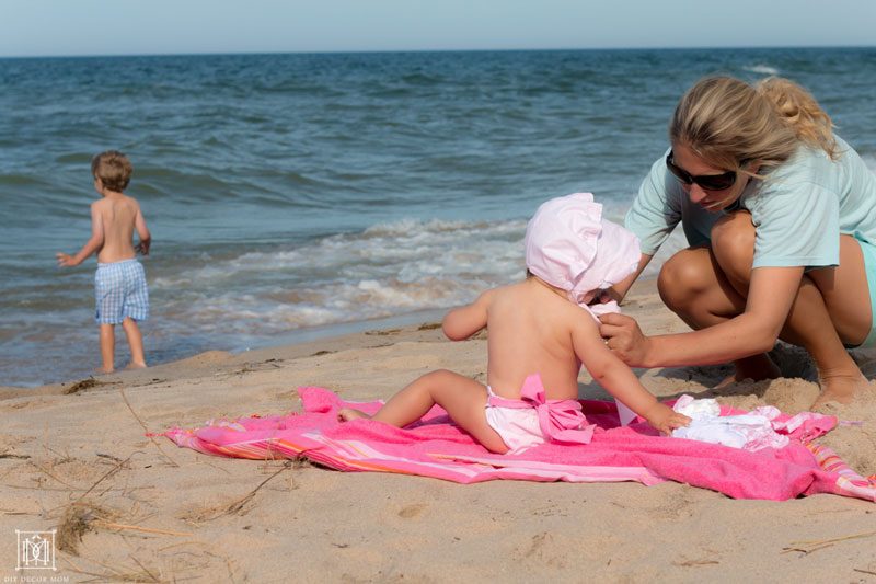 mom of three changing diapers at the beach