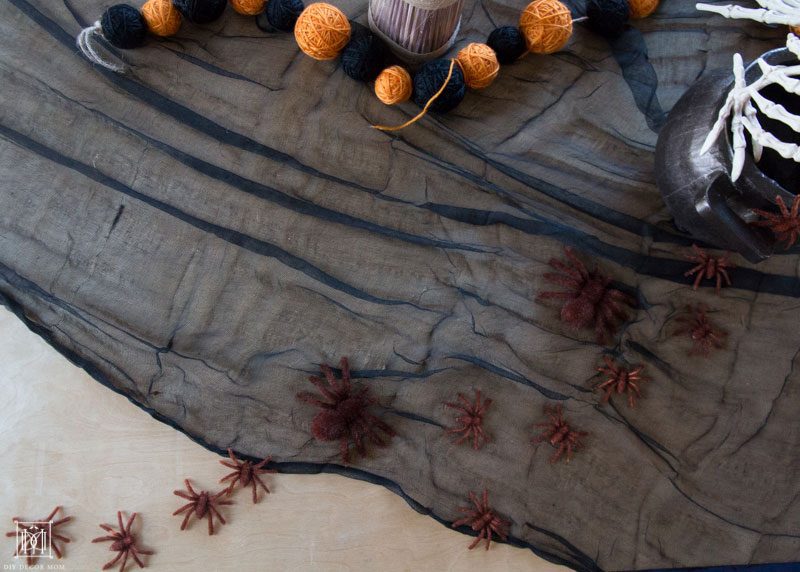 spiders on black tablecloth make spooky halloween decor ideas