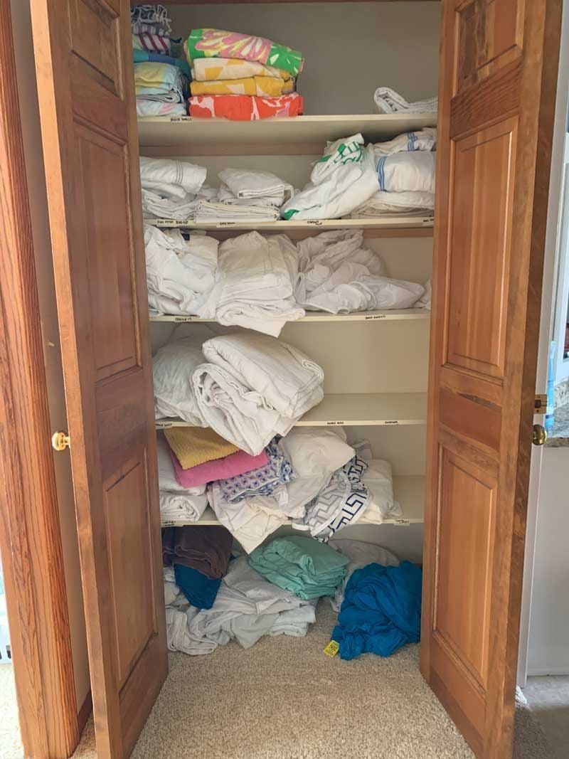 messy linen closet before makeover