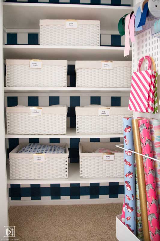 beautiful organized linen closet with white baskets