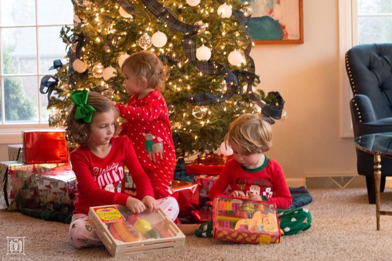 kids opening gifts in front of tree