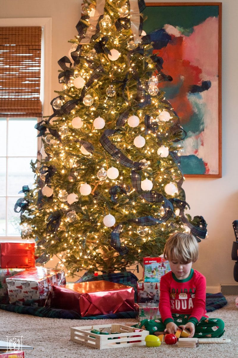 little boy playing with toys from meijer in front of tree