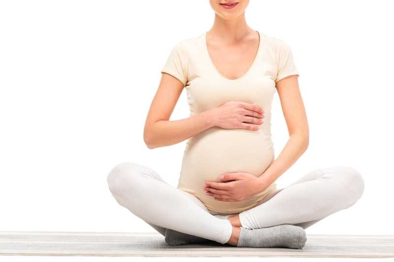 pregnant woman does yoga to decrease back pain while pregnant