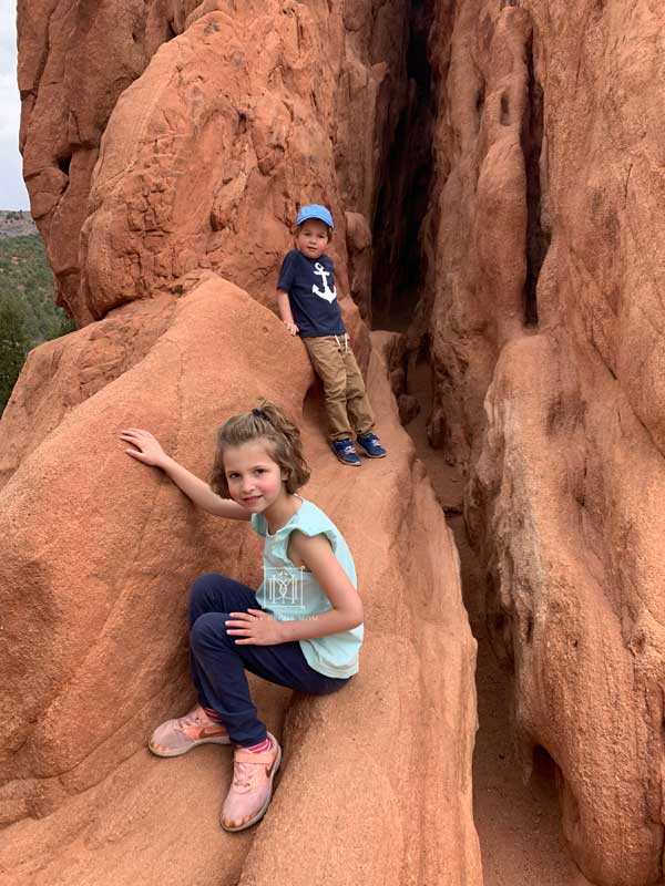 kids climbing rocks after family road trip