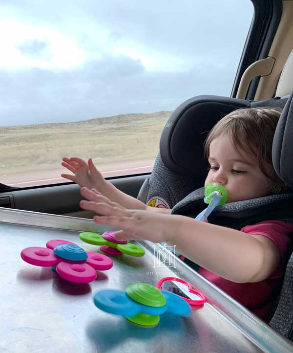 toddler playing with non-electronic road trip activities for kids