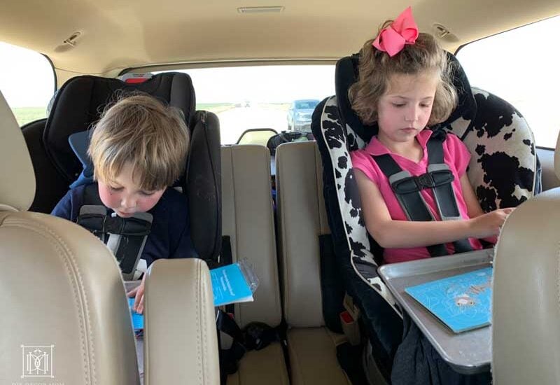 two kids in carseats doing road trip games and activities on family road trip