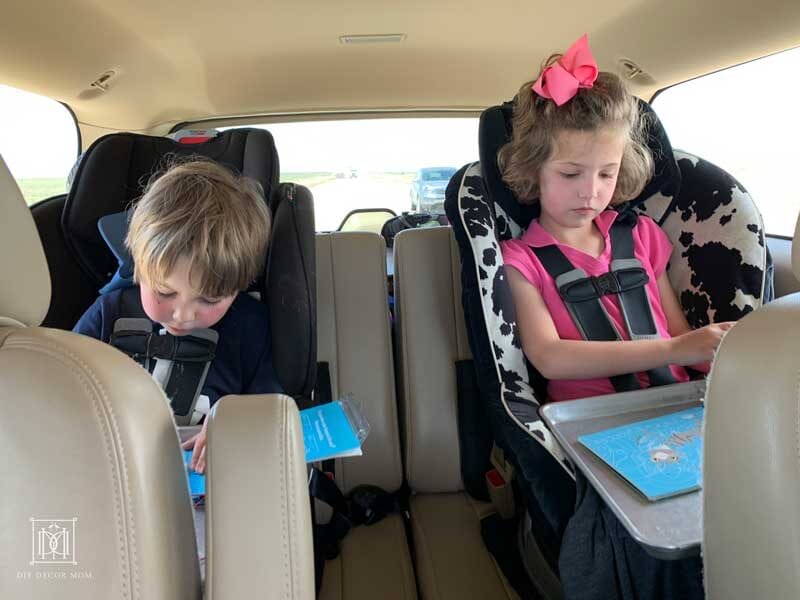 two kids in carseats doing road trip games and activities on family road trip