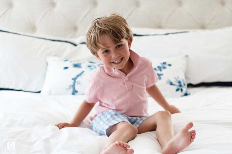 little boy sitting on bed